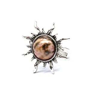Makroansicht eines Retro-Sonnenrings mit poliertem, marmoriertem Natursteinzentrum.