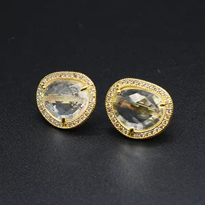 High-quality close-up of baroque style irregular faceted crystal stud earrings in gold