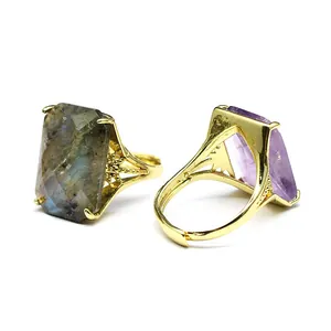 Detail view of two gold-plated open rings with large rectangular faceted natural stones