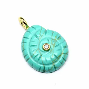 Detailed close-up carving of a turquoise conch shell pendant with a central zircon stone.