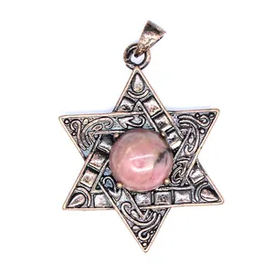Gros plan d'un pendentif Étoile de David en bronze vintage avec une pierre de Picasso rose