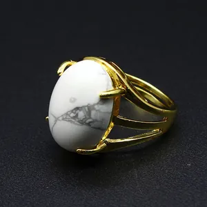 Vista macro dettagliata di un anello in pietra naturale bianca con fascia placcata oro 24k