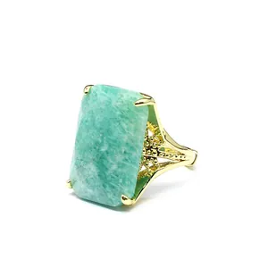 Detail view of a large rectangular green natural stone ring with gold filigree band