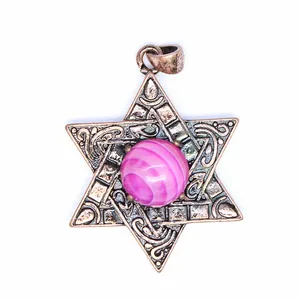 Gros plan d'un pendentif Étoile de David en bronze vintage avec pierre naturelle rose
