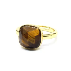 Gros plan d'une bague réglable plaquée or 24 carats avec une pierre œil de tigre carrée.