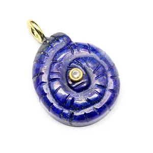 Close-up of carved lapis lazuli spiral shell pendant with central zircon detail.