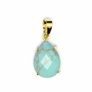 Gros plan détaillé d'un pendentif en turquoise facetté en forme de goutte avec bélière d'or