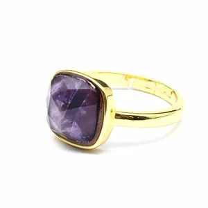 Gros plan d'une pierre d'améthyste violette sur une bague ouverte dorée de luxe