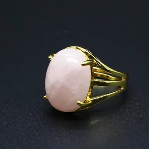 Primo piano di un anello placcato oro con una grande pietra naturale rosa ovale