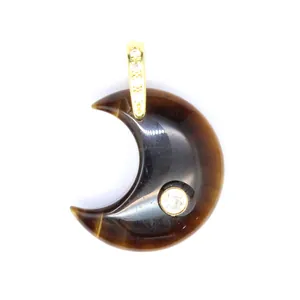 Close-up of tiger eye moon pendant with inlaid zircon and gold bail