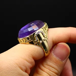 Close-up view of a large oval faceted purple amethyst ring with gold vintage engraving