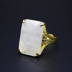 Detail of oversized rectangular natural stone ring in a gold-plated crown setting
