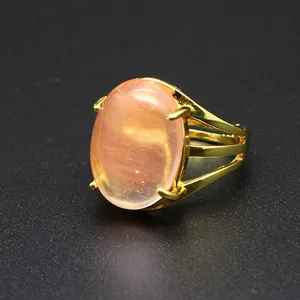 Vista dettagliata di una grande pietra naturale rosa ovale in un anello dorato 24k