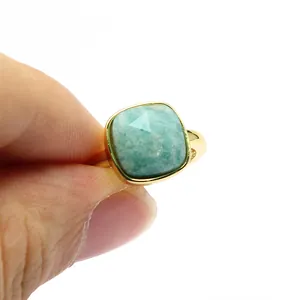 Gros plan d'une pierre d'amazonite carrée facettée sur une bague ajustable dorée
