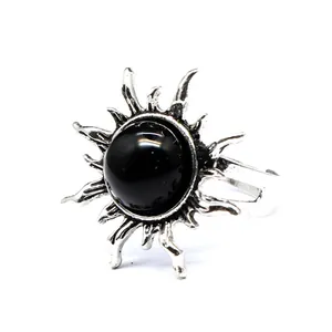 Nahaufnahme eines Vintage-Rings in Sonnenform mit einem polierten schwarzen Naturstein