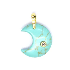 Detail macro view showing crescent moon pendant with turquoise stone and zircon inlay