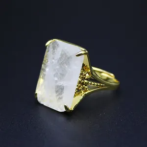 Detail view of a large rectangular natural stone ring with an ornate gold-plated setting