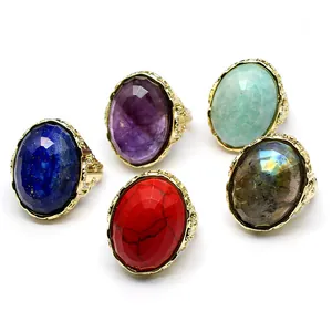 Detailed view of five faceted oval natural stone rings in various colors and gold settings