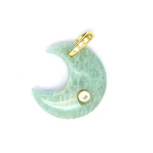Close-up detail of a moon-shaped green natural stone pendant with gold accents