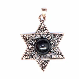 Gros plan d'un pendentif hexagramme vintage avec des motifs et une pierre noire.