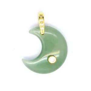 Close-up of a green moon-shaped natural stone pendant with gold zircon inlay.