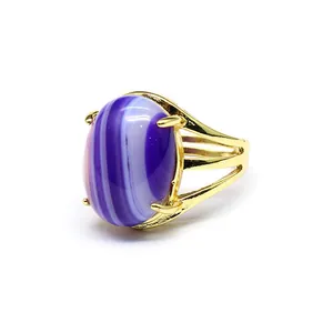 Primo piano di un anello placcato oro 24 carati con pietra d'agata striata viola e bianca.