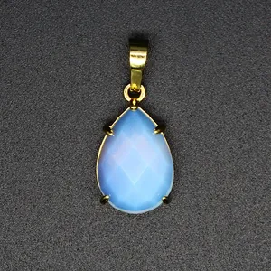 Détail d'un pendentif goutte facetté en pierre naturelle bleue avec bélière dorée