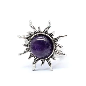 Exquisiter Vintage Sonnenring mit rundem lila Naturstein auf weißem Hintergrund.