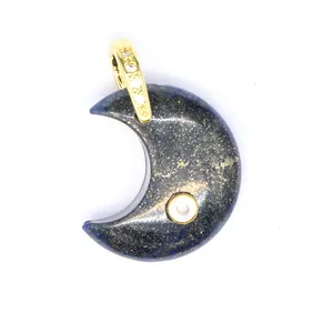 Close-up of crescent moon pendant made of natural blue stone with gold-framed zircon