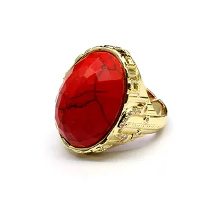 Macro view of a large faceted red stone ring with gold setting and adjustable open band