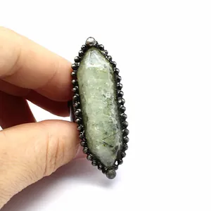 Vista macro de un anillo vintage con una gran piedra natural verde de forma hexagonal.