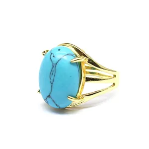 Dettaglio di un anello placcato in oro con una grande pietra ovale turchese