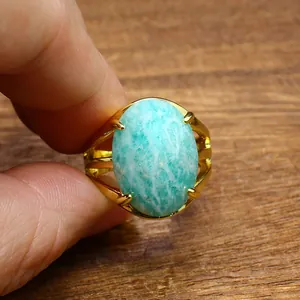 Detailed view of a vintage gold ring with a large oval faceted amazonite stone.
