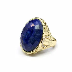 Close-up of ornate gold ring featuring a large faceted oval lapis lazuli stone.