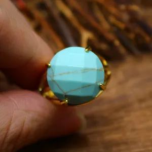 Nahaufnahme-Makrodetail eines facettierten Rings im Türkis-Stil mit Goldkrallenfassung