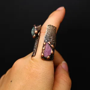 Close-up detail of a vintage medieval style open ring featuring natural raw gemstones