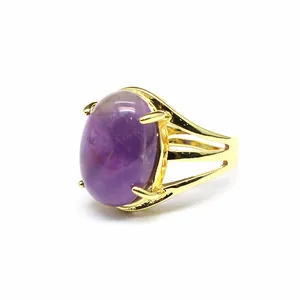 Vista laterale di un anello placcato oro 24k con una grande pietra viola ovale
