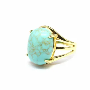 Dettaglio ravvicinato di un anello in turchese ovale con fascia divisa placcata oro 24k