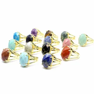 Detailed view showing various faceted oval natural gemstone rings in gold-tone open bands