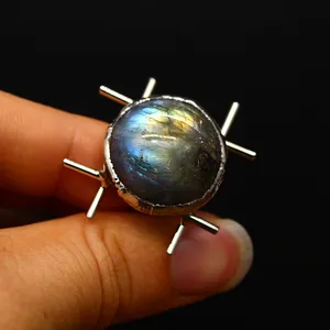 Detailed macro view of a natural iridescent labradorite stone set in a medieval sunburst ring