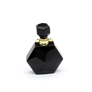 Détail d'un pendentif en pierre noire facettée en forme de flacon avec bélière dorée.
