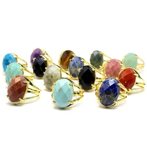 Macro view of various oval faceted natural stone rings in gold-colored adjustable bands