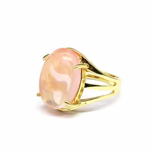 Dettaglio di un anello regolabile placcato oro 24k con una grande pietra naturale rosa.