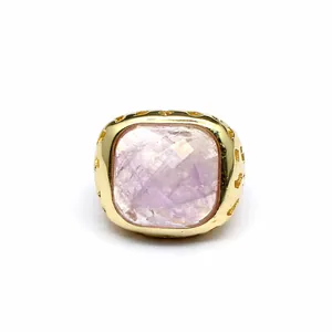 Primo piano di una grande pietra di ametista sfaccettata su un anello placcato oro 24k.