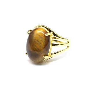 Dettaglio di un anello regolabile placcato oro con una pietra occhio di tigre ovale