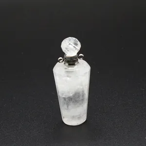 Close-up of clear quartz perfume bottle pendant with faceted crystal cap and silver loops.