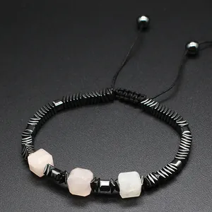 Vista detallada de pulsera tejida a mano con cubos de cristal rosa y cuentas de hematita.