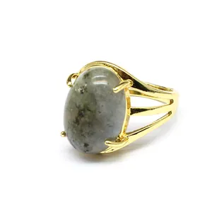 Primo piano di un anello placcato in oro con grande pietra naturale grigia ovale