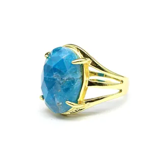 Detail view of a vintage gold ring featuring a large faceted oval blue apatite stone