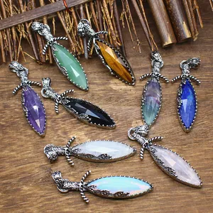 Detail view of assorted natural stone sword pendants with vintage silver hilts on wood